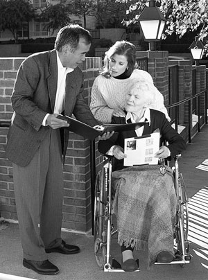 Picture of man and woman looking at house with a "for sale" sign